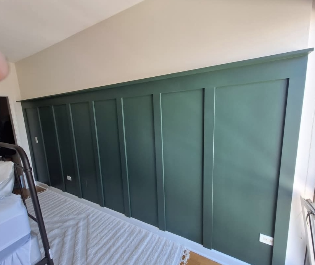 Bedroom with green wainscoting accent wall