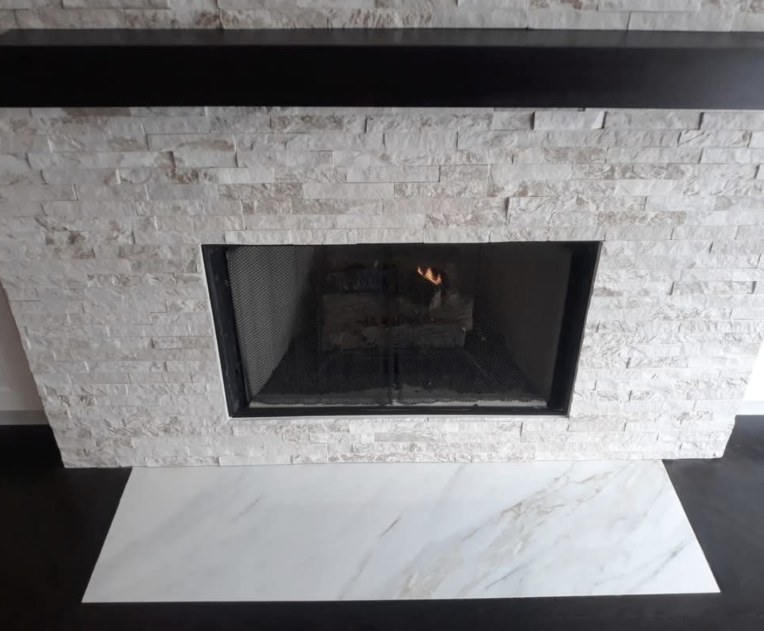 Finished stacked-stone fireplace with marble hearth