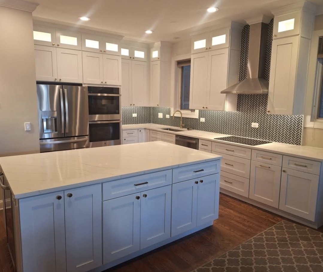 Remodeled kitchen with island, herringbone tile backsplash and range hood