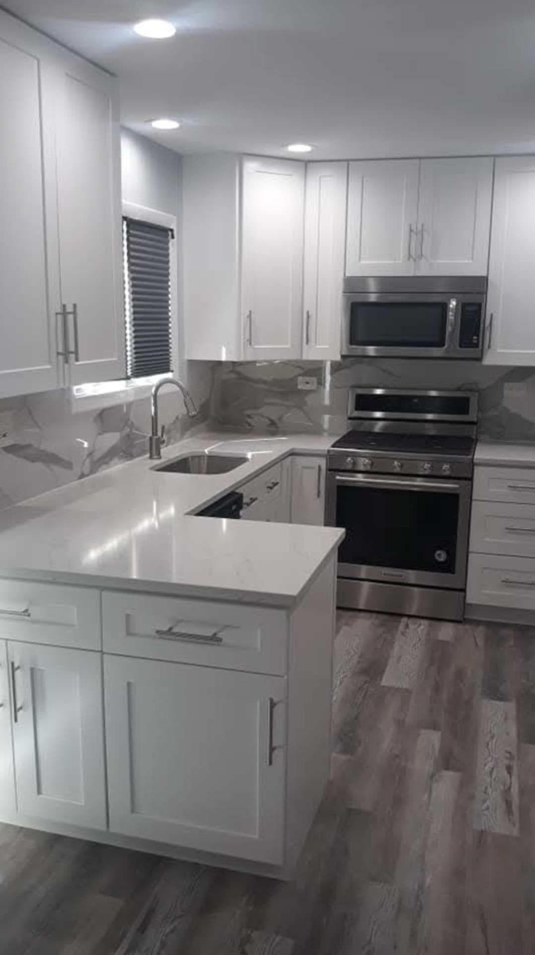 Kitchen with gray tile and white cabinetry