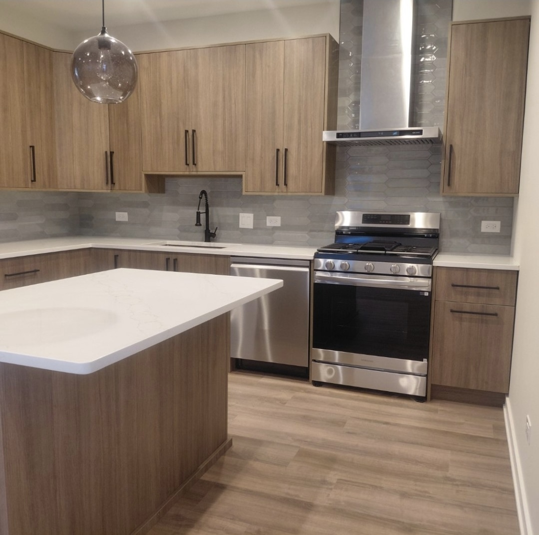 Modern kitchen with wood-tone cabinetry and pendant lighting