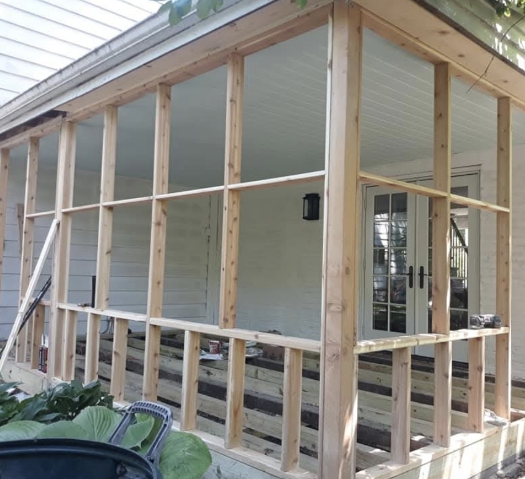 Screened porch under construction, open stud framing